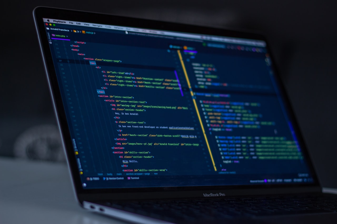 Developer working on laptop with code on screen